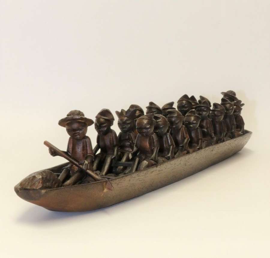 An African Carved Wooden Model Of A Dug-out Canoe With 18 Seated Tribal Figures.
