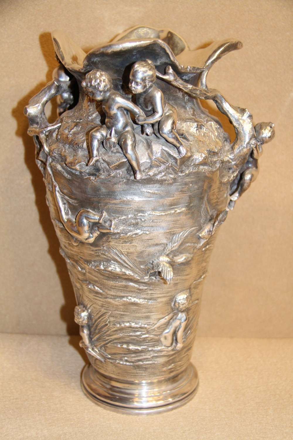 A Large And Decorative Silver Plated Vase Embellished With Water Nymphs  Casting Their Nets Into A Lake.