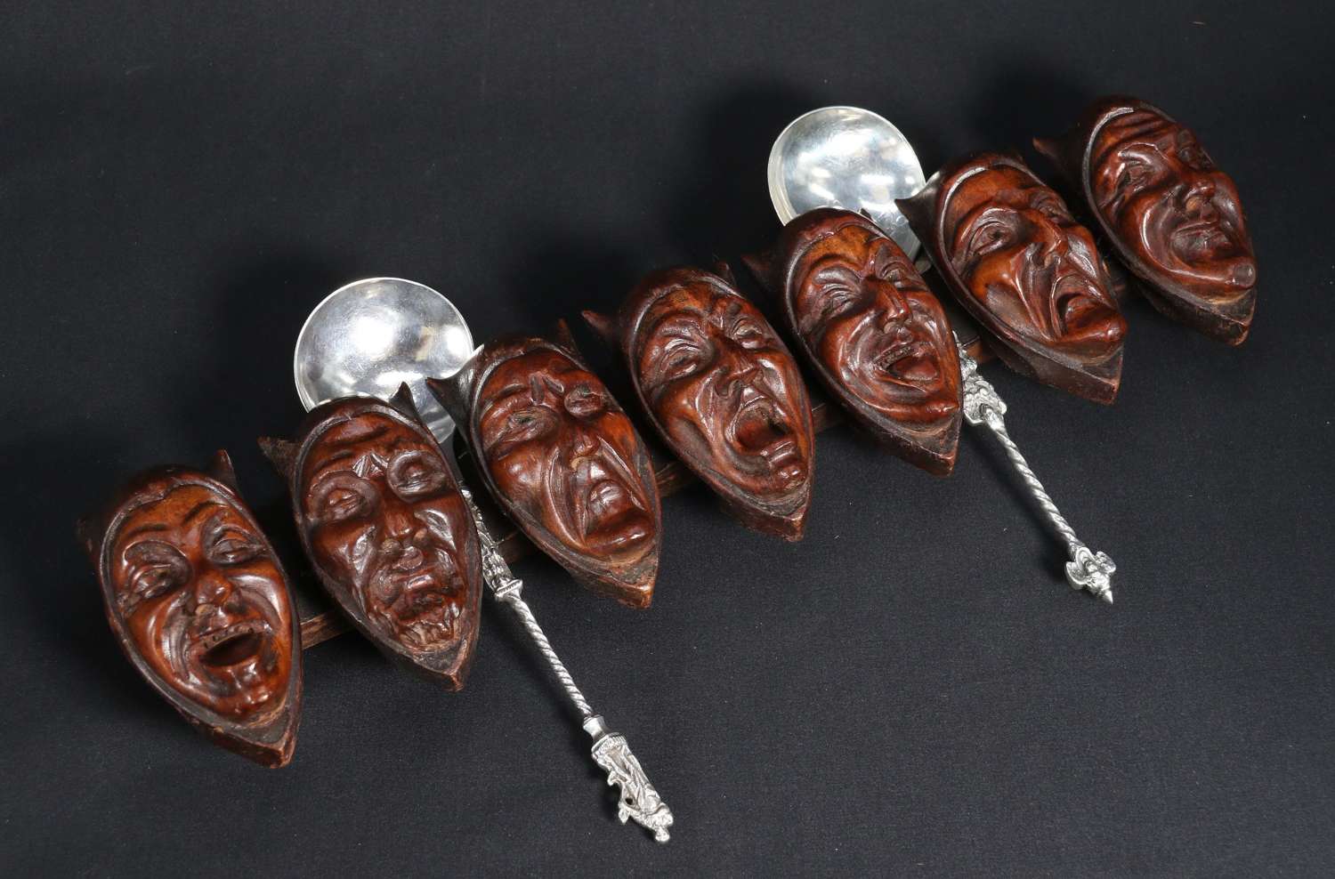 Black forest spoon rack depicting the faces of the 7 sins, c 1880