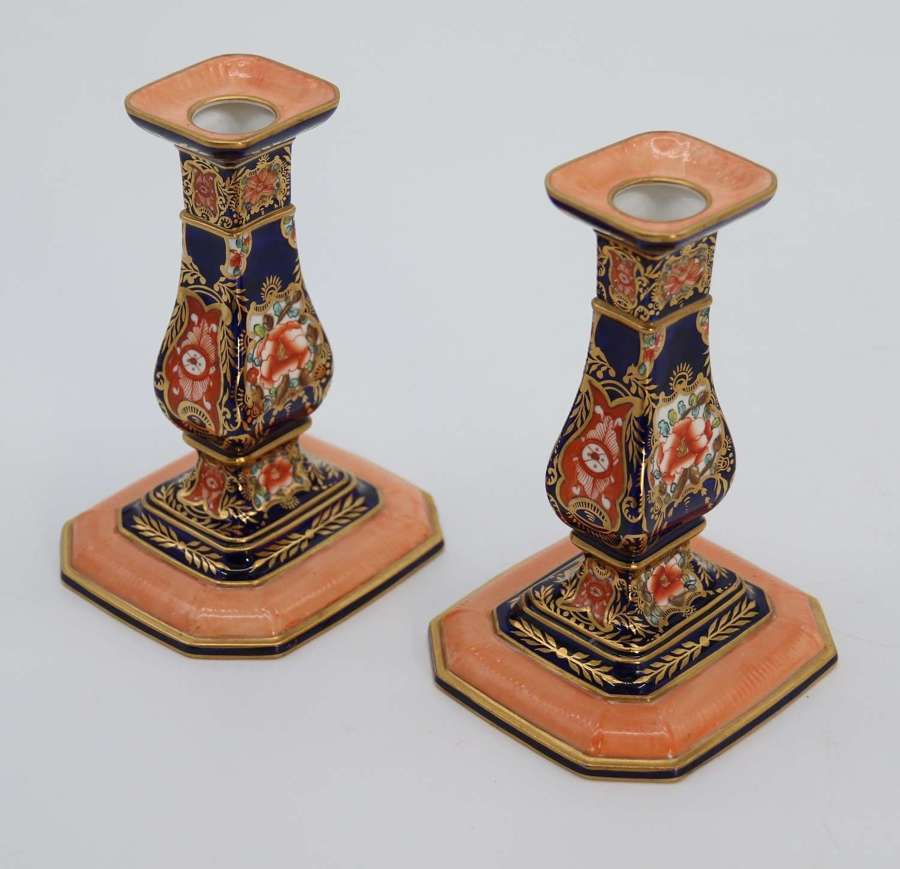 A pair of hand painted Royal Crown Derby candlesticks, circa 1911