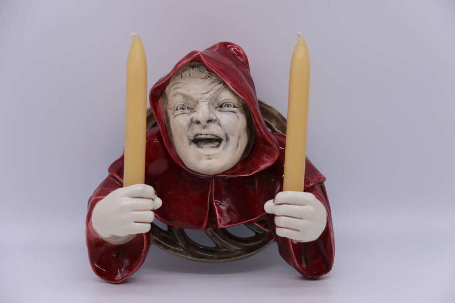 An Austrian pottery wall hanging candelabra in the form of a monk.