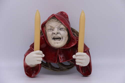 An Austrian pottery wall hanging candelabra in the form of a monk.