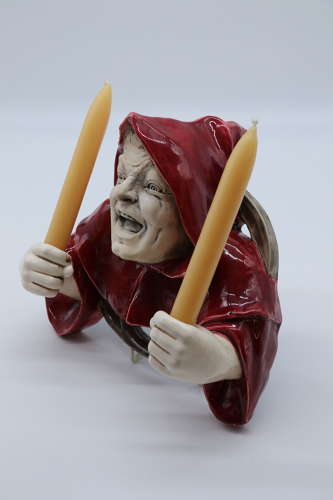 An Austrian pottery wall hanging candelabra in the form of a monk.