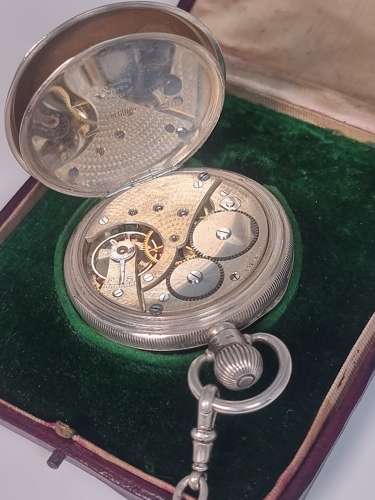 A solid silver pocket watch, presentation case and chain with two fobs