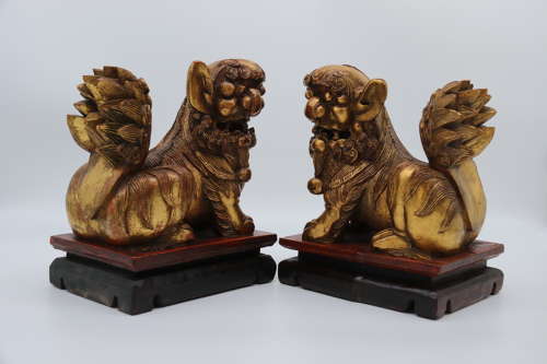 A pair of Chinese carved gilt wood and lacquer Buddhist lions C 1900