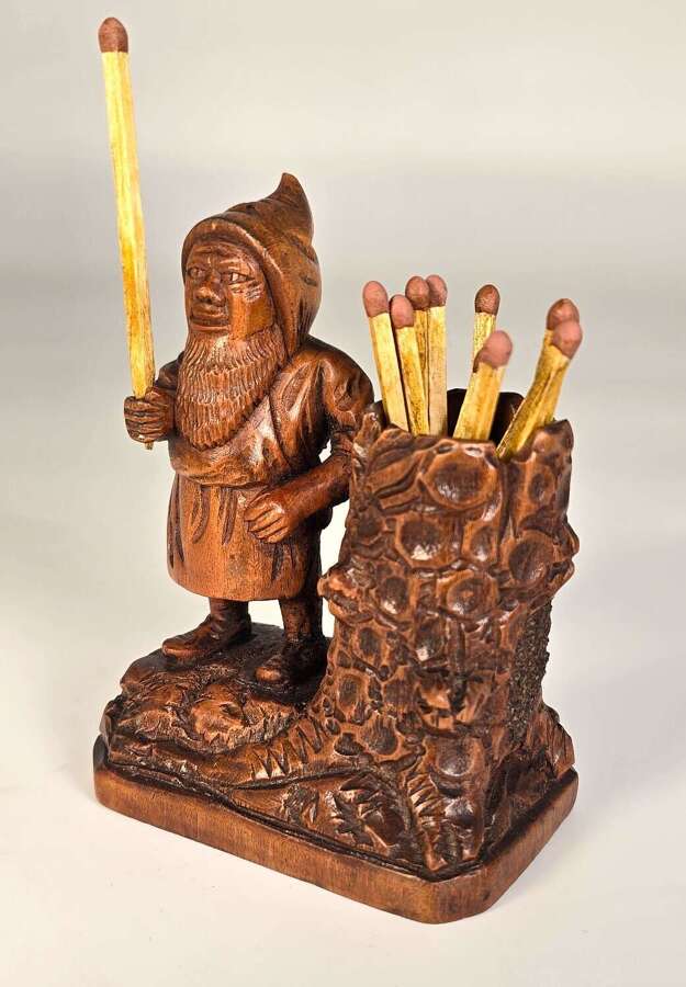 A carved Black Forest novelty gnome match holder and striker made in 1916