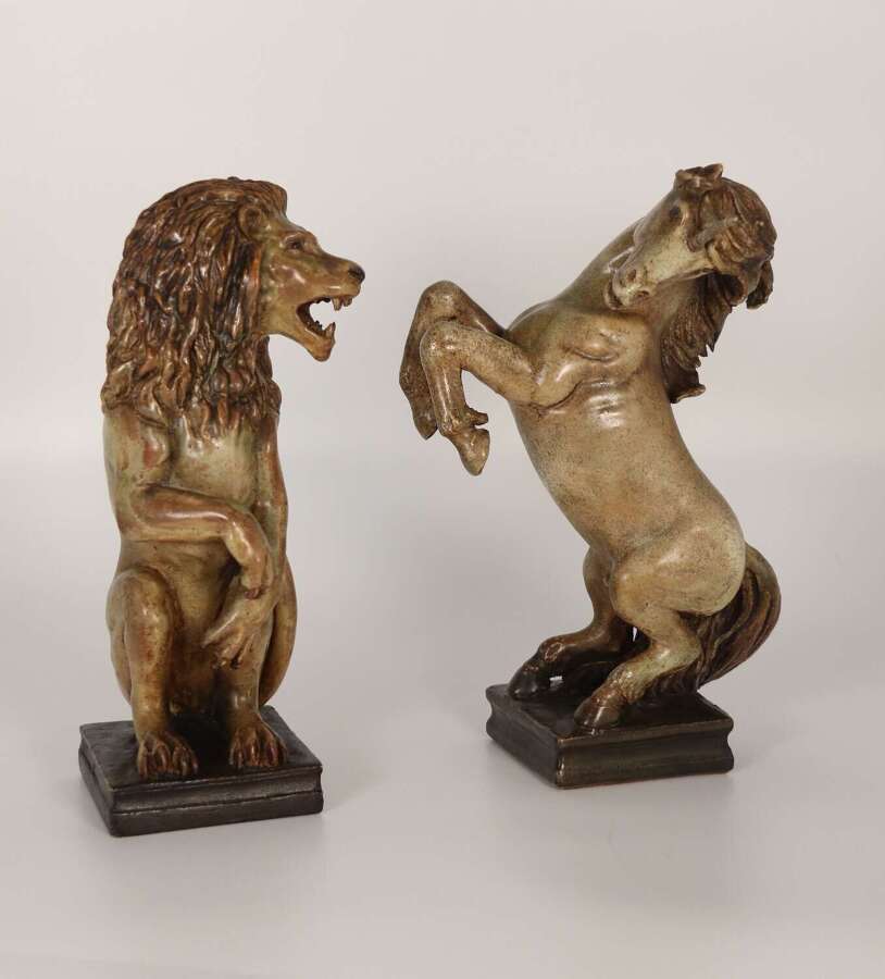 A pair of pottery hand sculpted figures of heraldic lion and unicorn