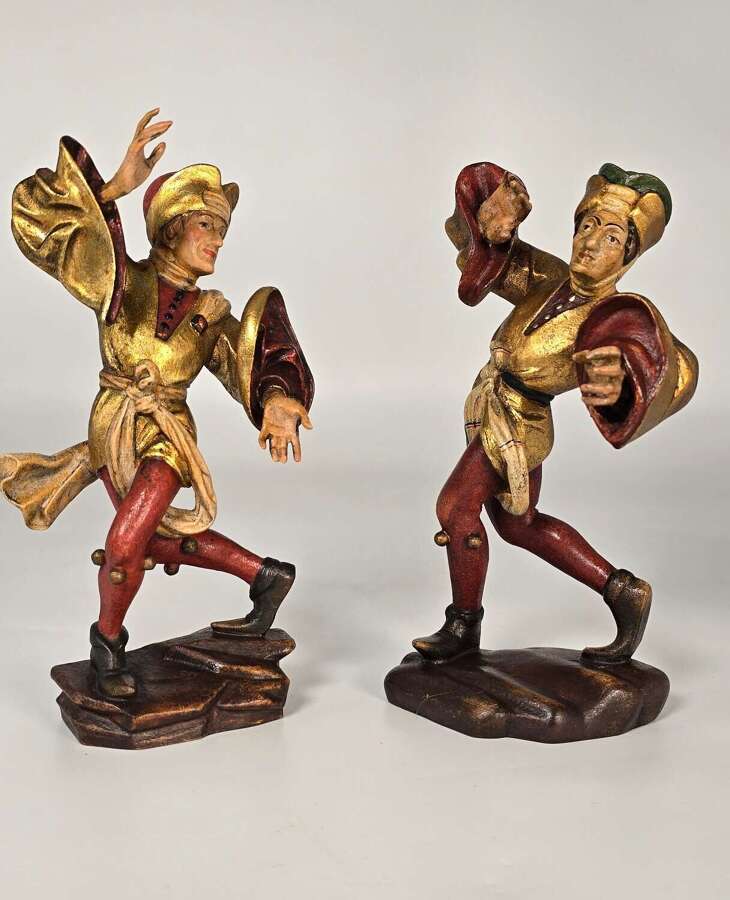 A rare pair of Swiss or Black Forest carved and polychrome and gilt painted jester figures